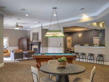 A room with a pool table and a fireplace.